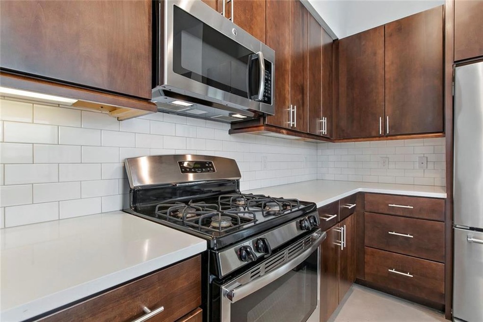 Kitchen featuring stainless steel appliances, lig