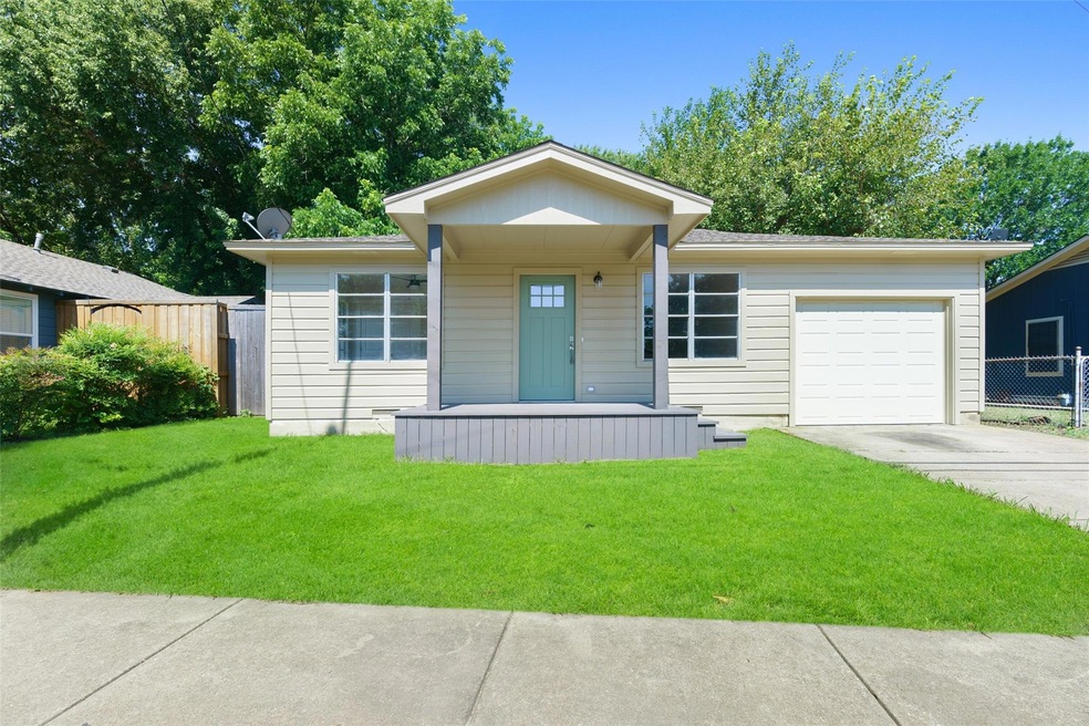 View of front of house with a front yard and a gar