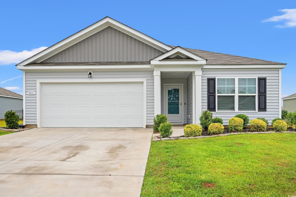 Ranch-style home featuring a front yard, concrete driveway, board and batten siding, and an attached garage