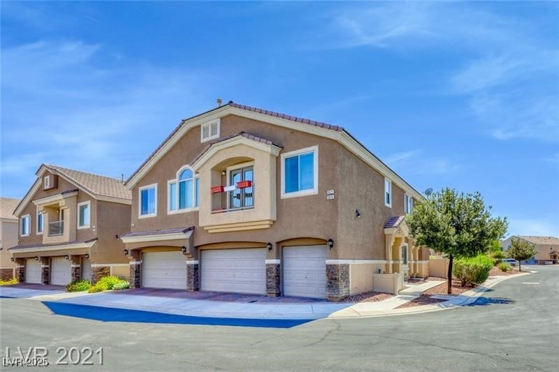 View of front of home with stucco siding, an attac
