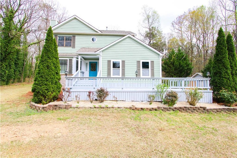 View of front of house with a front yard, a chimney, and a deck