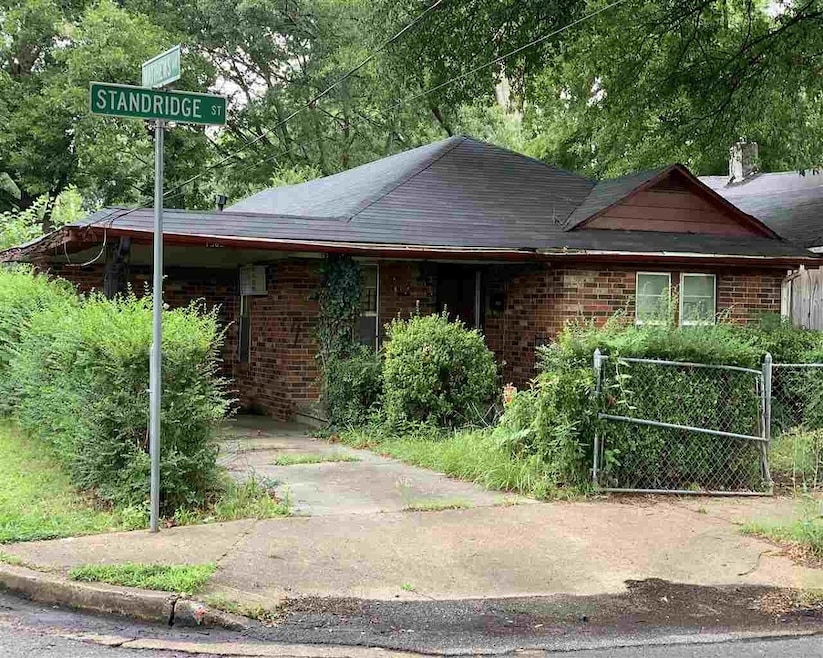 View of property exterior with brick siding and roof with shingles