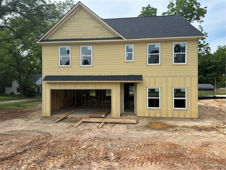 View of front of property with a garage, board and
