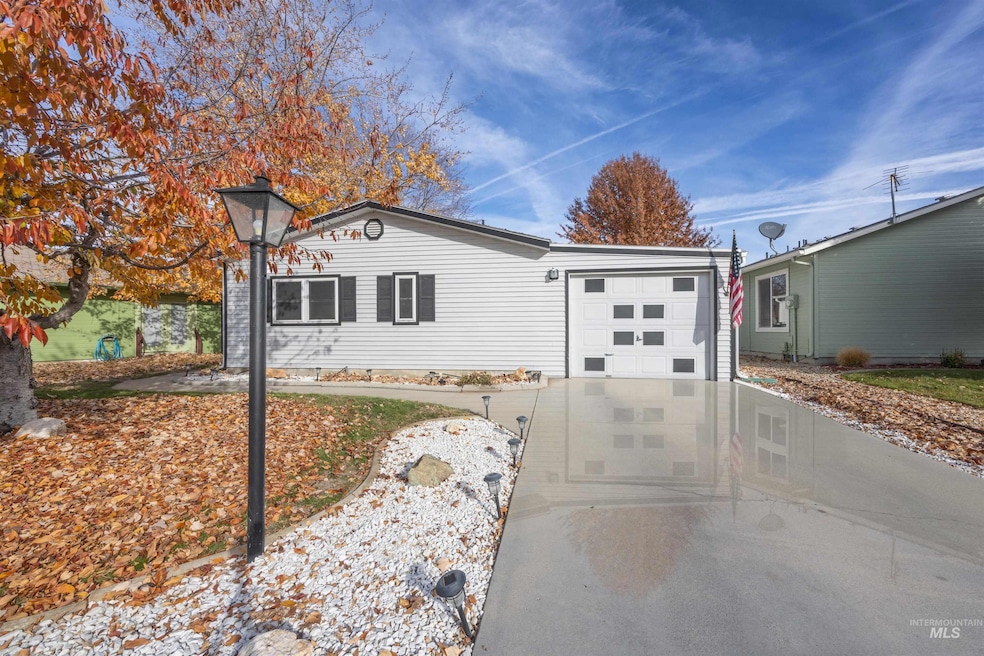 Ranch-style home with driveway, a chimney, and an attached garage