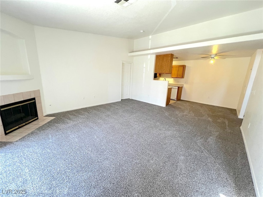 Unfurnished living room with carpet, ceiling fan,