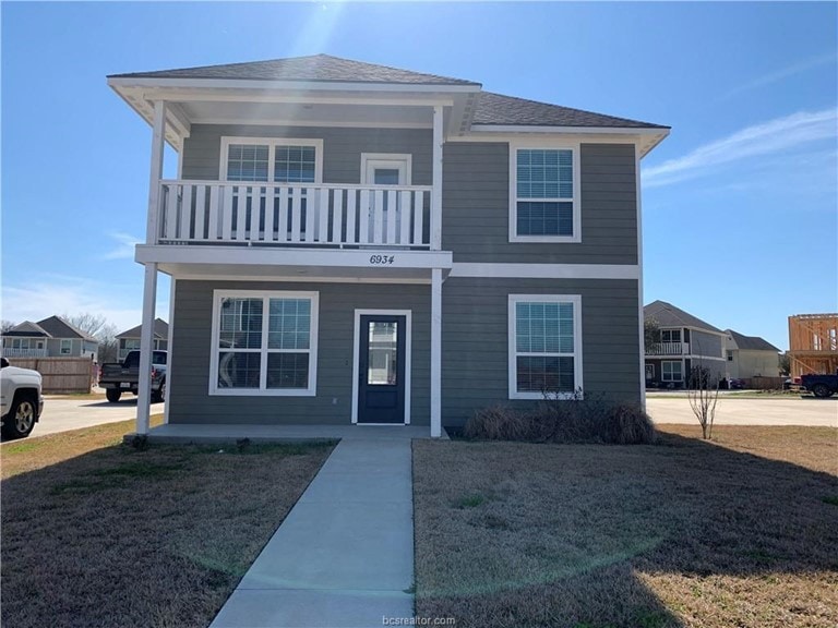 View of front of home with a balcony, a porch, a f