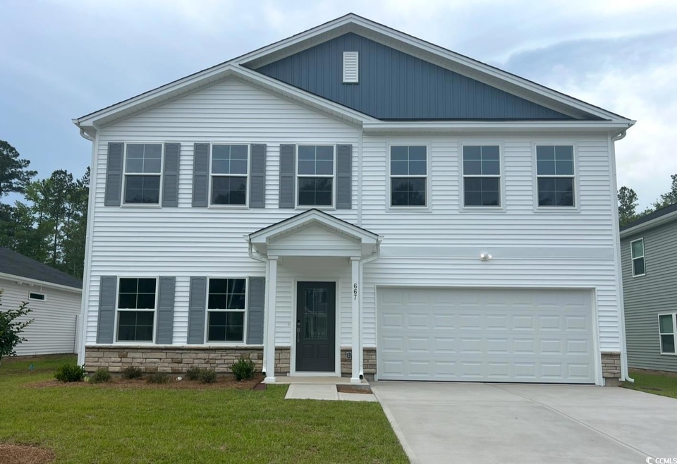 View of front of home with a garage, concrete driv