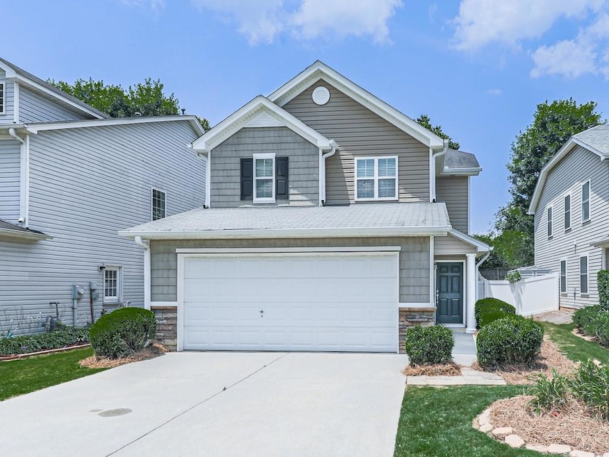 Craftsman-style house with stone siding, concrete driveway, and an attached garage