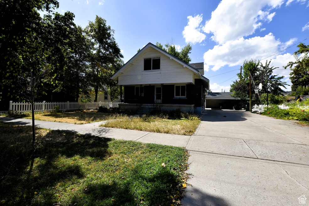 Bungalow featuring a porch and concrete driveway