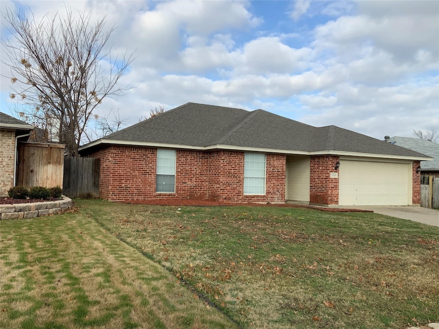 Ranch-style house with a shingled roof, brick siding, a garage, and driveway