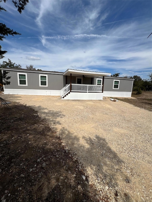 View of front of home with covered porch and dirt driveway