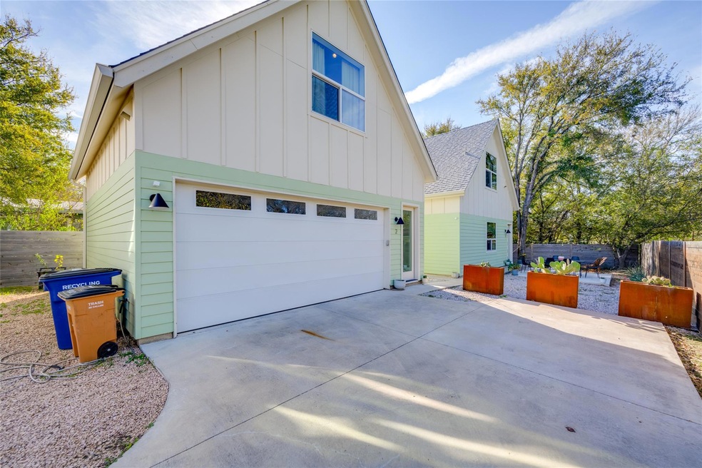 View of side of home with fence, a garage, board 
