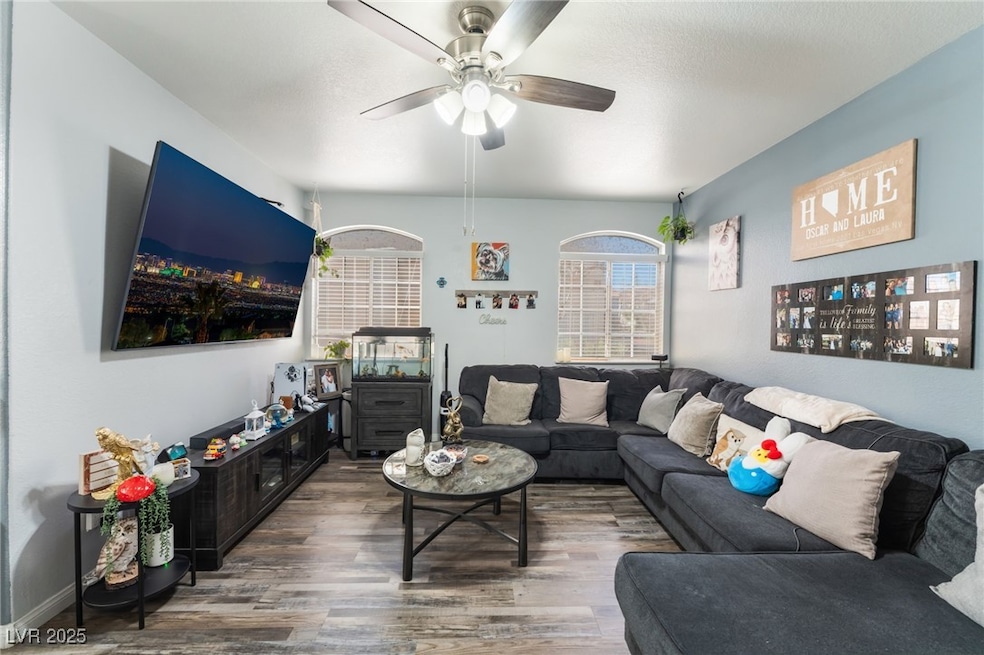Living area featuring wood finished floors and ceiling fan
