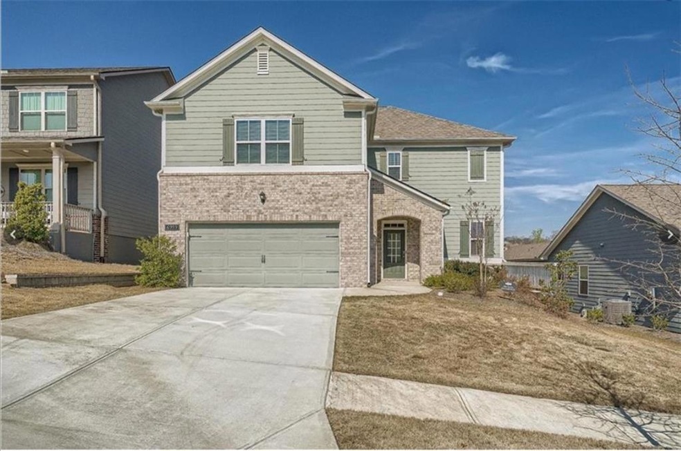 View of front of home with brick siding, an attached garage, and driveway