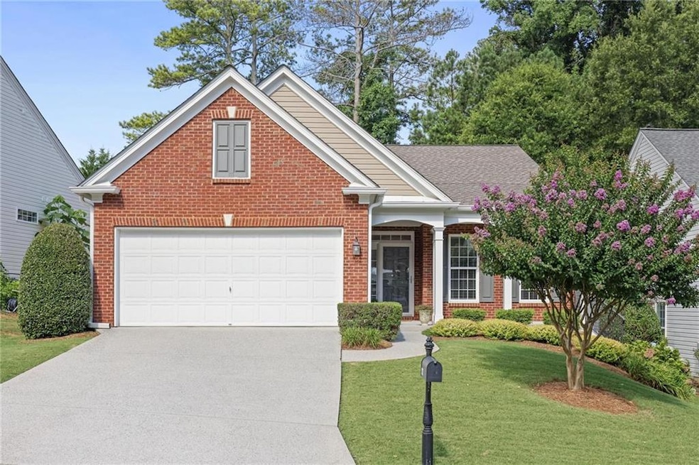 Traditional-style home with brick siding, concrete driveway, a front lawn, and a garage