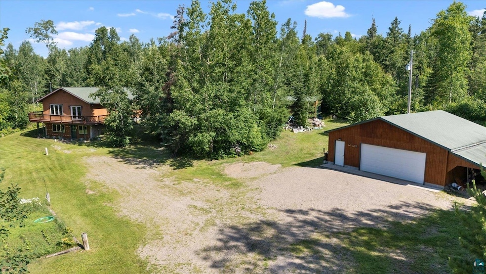 Aerial view of property and surrounding area featuring a heavily wooded area