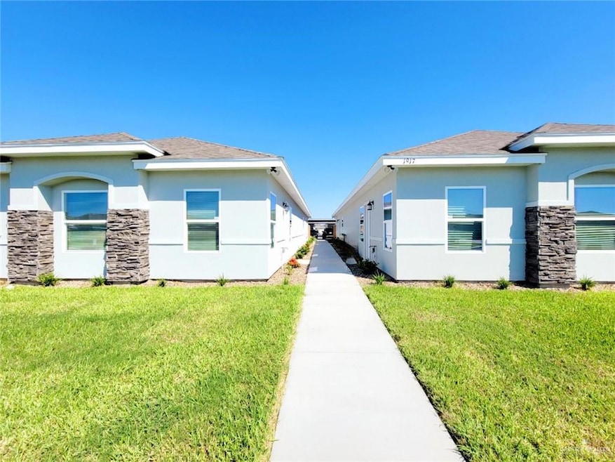 View of property exterior featuring a yard, stone siding, and stucco siding
