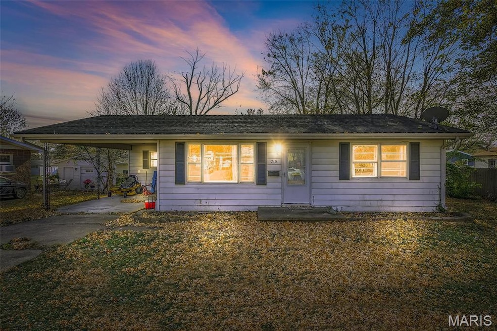 View of front of home featuring a carport, driveway, and a lawn