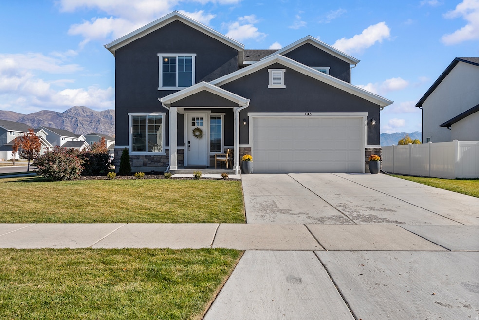 Traditional home featuring a mountain view, stucco siding, concrete driveway, and stone siding