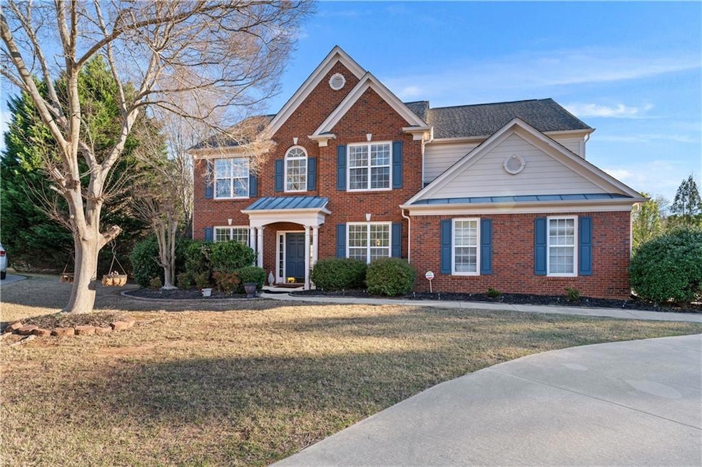 View of front of house featuring a front lawn, bri