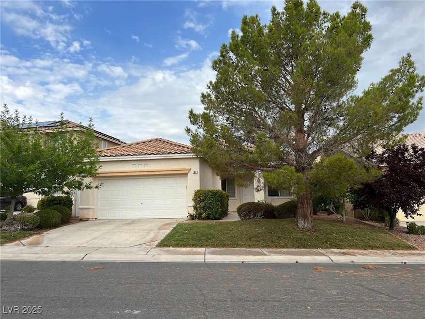 View of front of house featuring stucco siding, an attached garage, driveway, a tiled roof, and a front yard