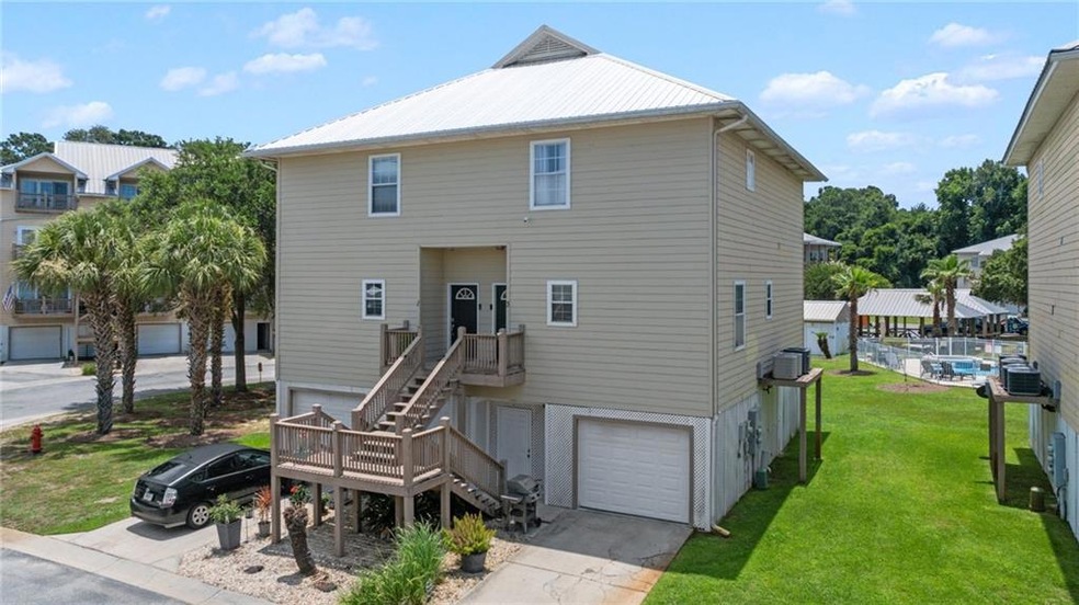 View of front of house featuring an attached garage, driveway, a front yard, and a metal roof