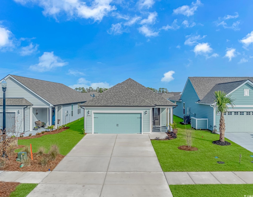 View of front of home with a front yard and a gara