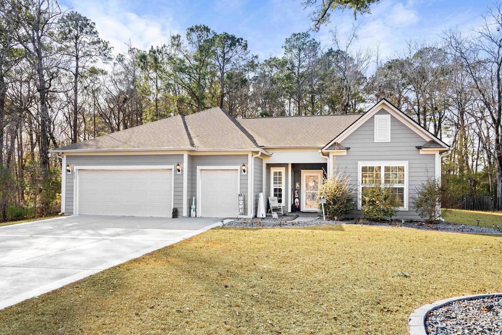 Ranch-style home featuring a front yard and a gara