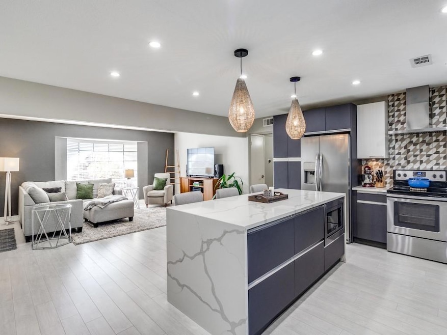 Kitchen with wall chimney exhaust hood, light hard
