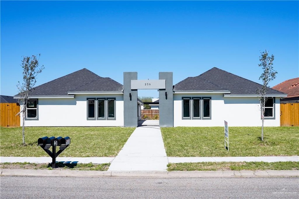 View of front of property featuring a front yard, fence, and stucco siding