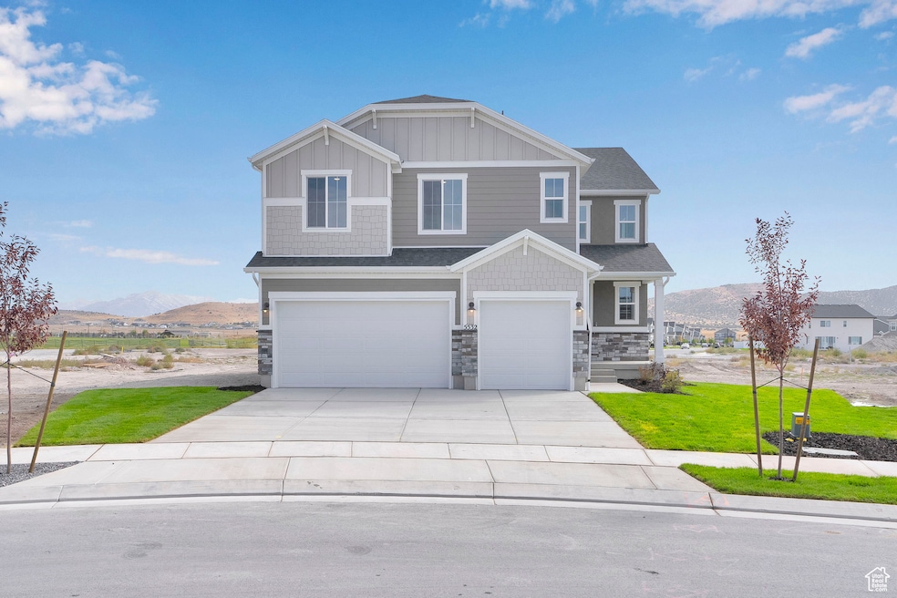 Craftsman inspired home featuring board and batten siding, an attached garage, a mountain view, and concrete driveway