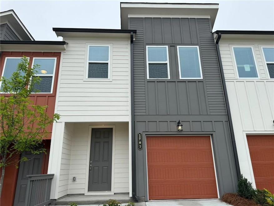 View of front of house with board and batten siding and an attached garage