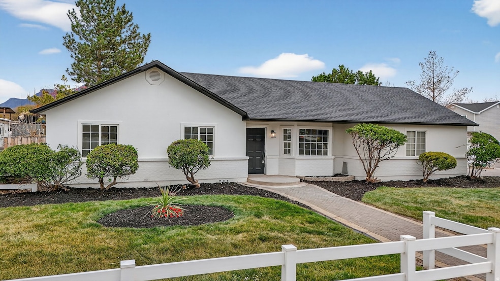Ranch-style house with roof with shingles, stucco siding, and brick siding