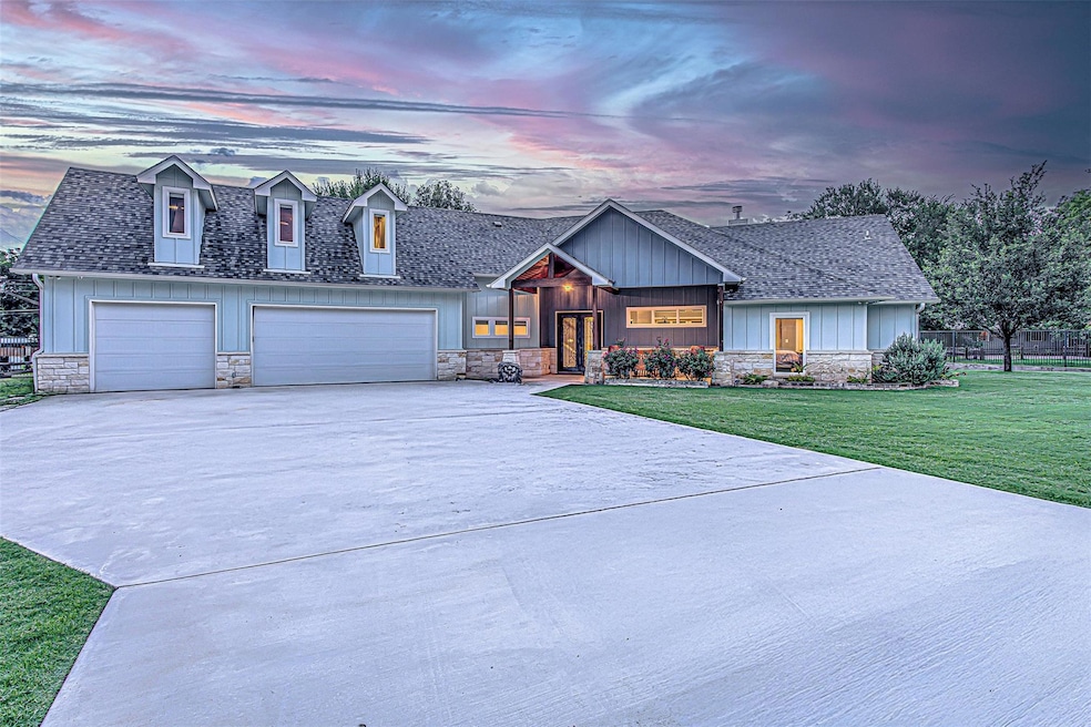 View of front facade with stone siding, driveway,