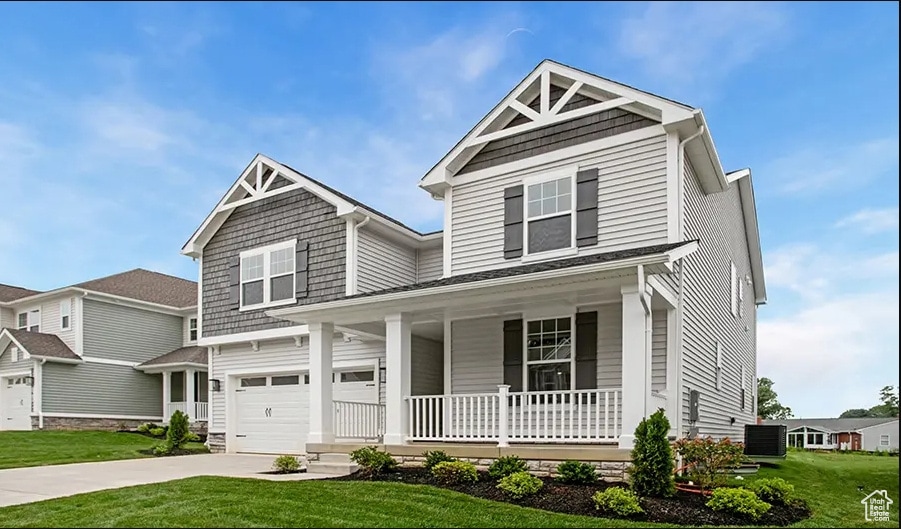 Craftsman inspired home featuring a porch, a front yard, concrete driveway, and a garage