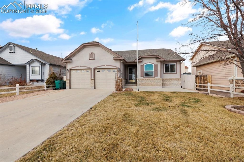 Ranch-style house featuring a front lawn and a gar