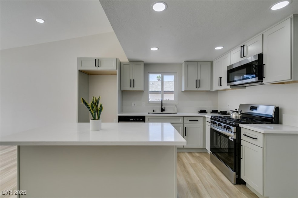 Kitchen with stainless steel appliances, a sink, l