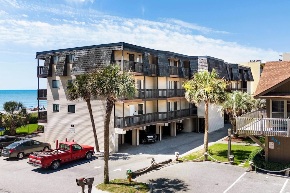 View of building exterior featuring uncovered parking and a water view