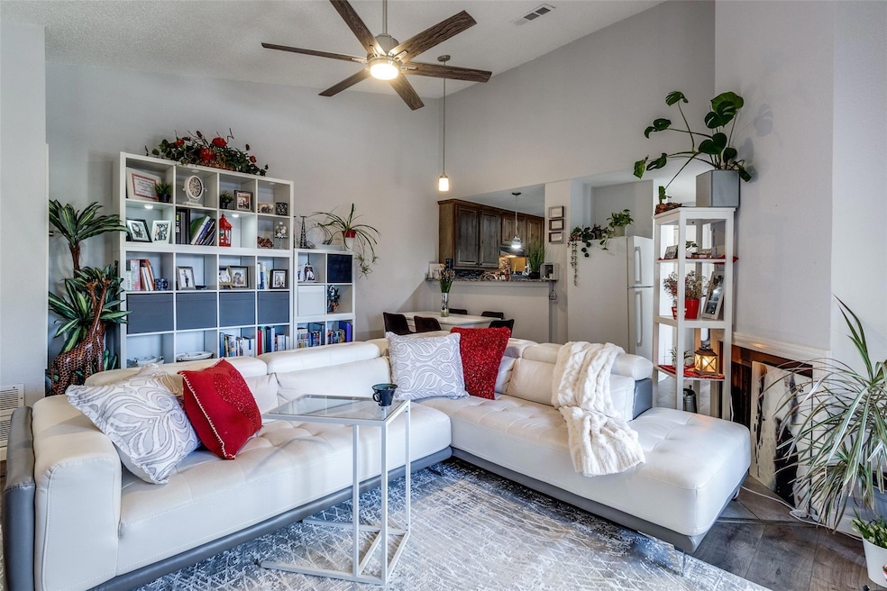 Living room with a high ceiling, visible vents, a 