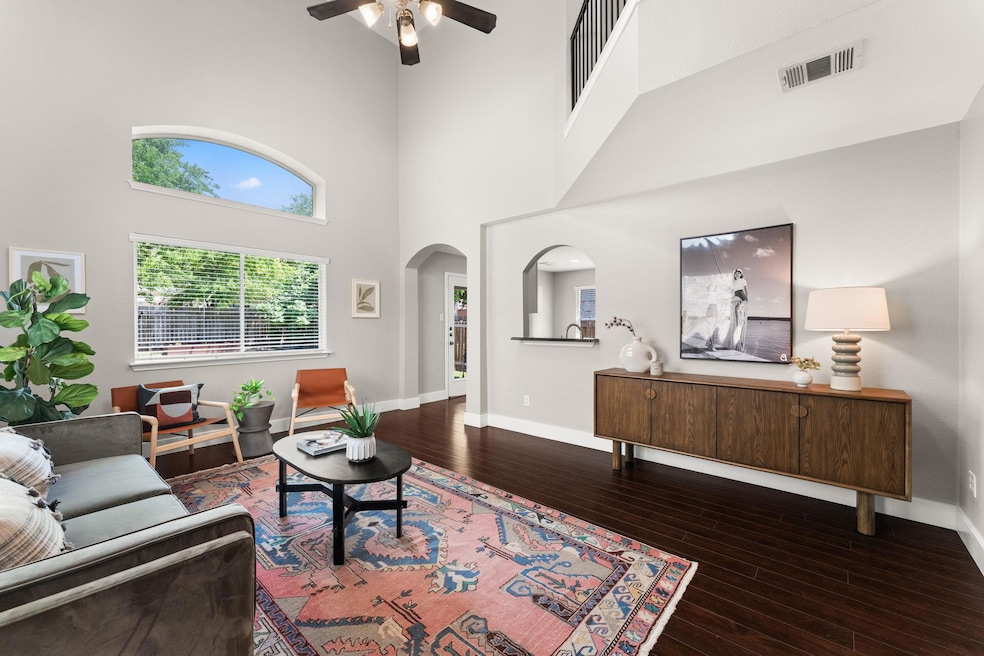 Living room featuring a ceiling fan, hardwood / w