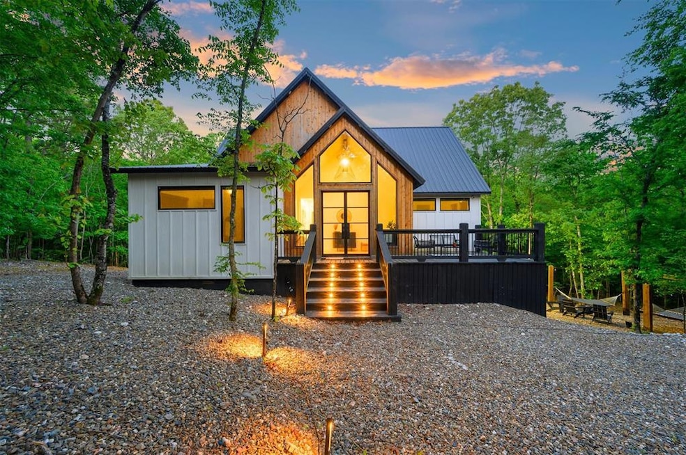 Rear view of house with board and batten siding, a deck, and metal roof