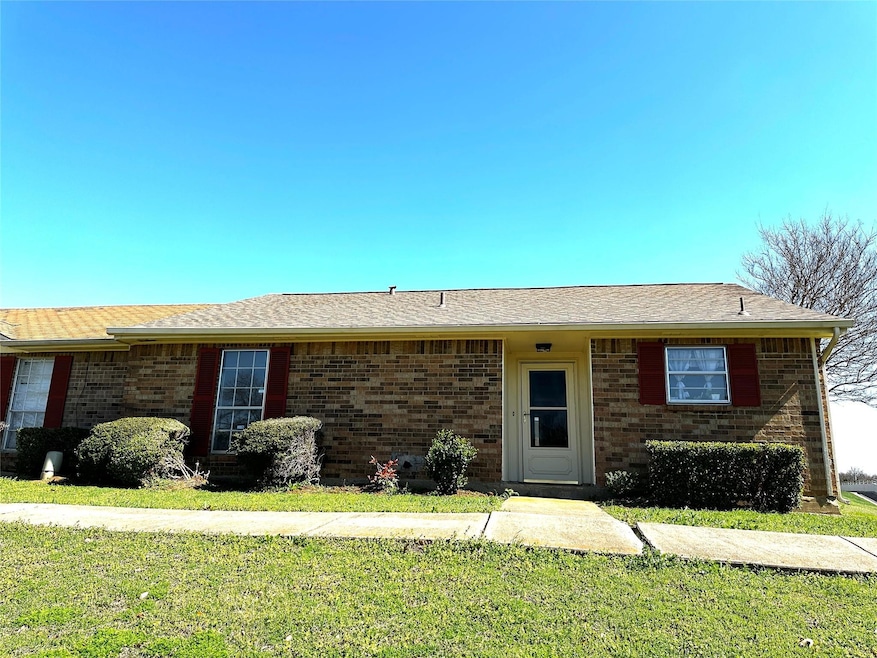 Single story home with a front yard and brick sidi