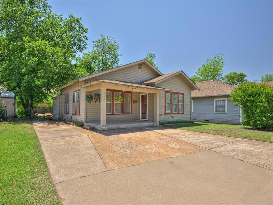 View of front of property with a front lawn, a porch, and driveway.
