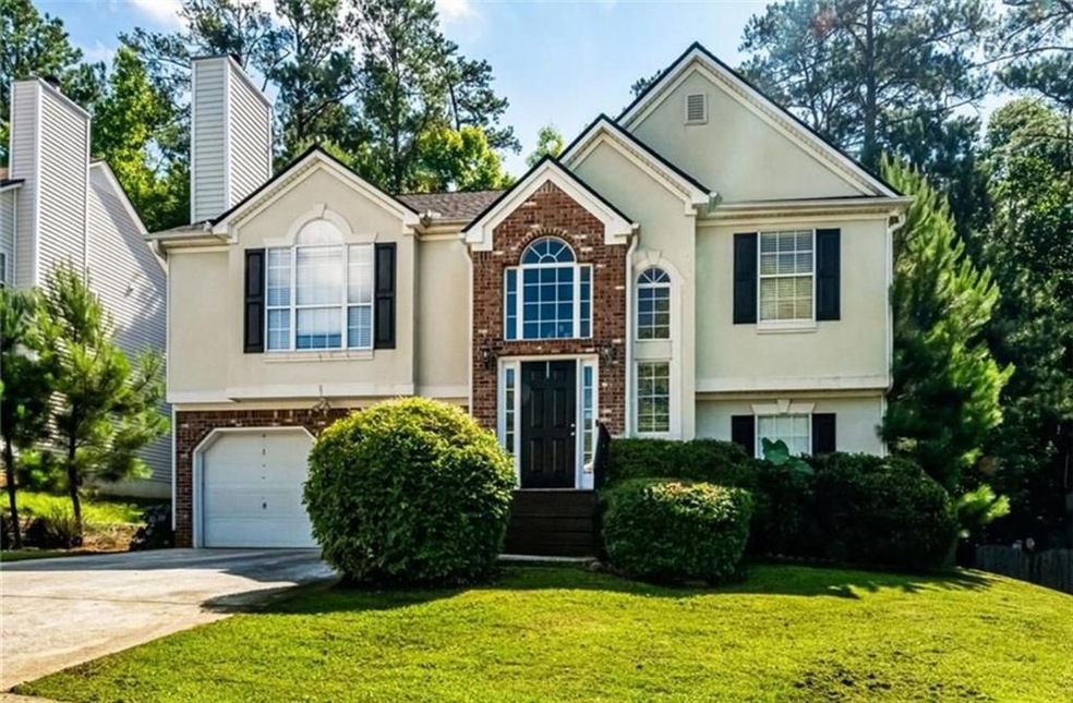 View of front of house with a front lawn and a gar