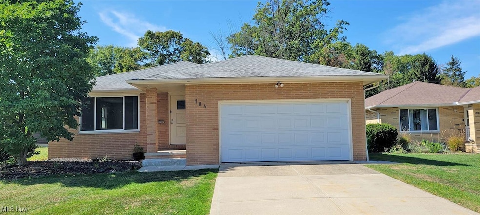 Ranch-style home featuring a front yard, brick siding, and concrete driveway