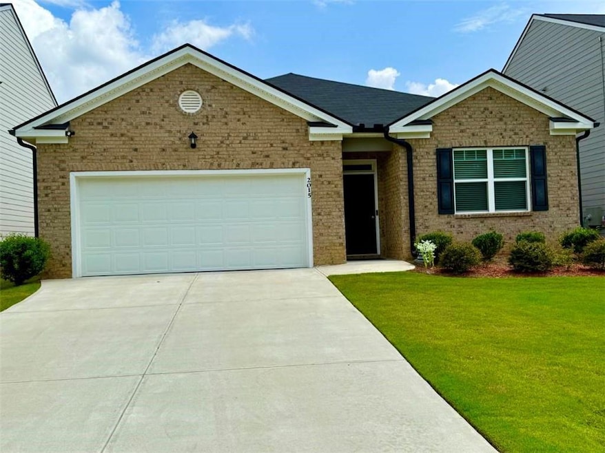 Ranch-style house featuring a front yard, a garage, concrete driveway, and brick siding