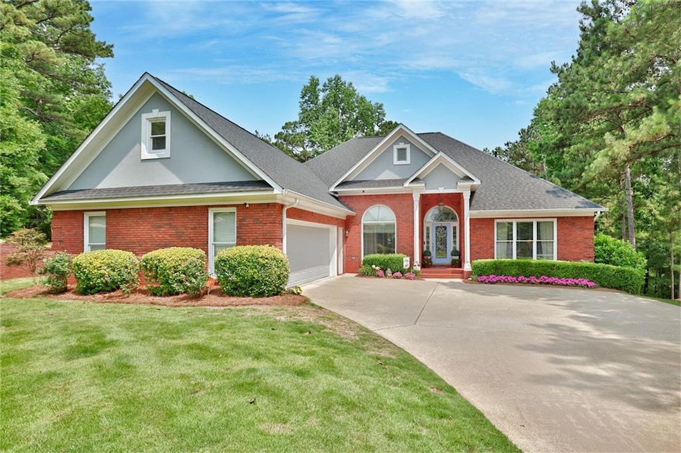 View of front of property with driveway, brick siding, an attached garage, a front lawn, and a shingled roof