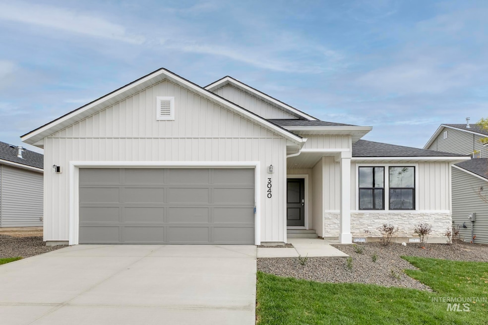 View of front facade featuring board and batten siding, a shingled roof, a garage, driveway, and stone siding