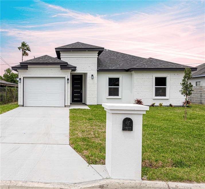 View of front facade featuring an attached garage, roof with shingles, concrete driveway, and a front lawn
