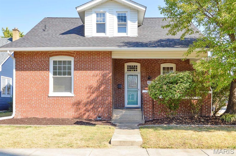 View of front of home featuring a porch, brick siding, a shingled roof, and a front lawn